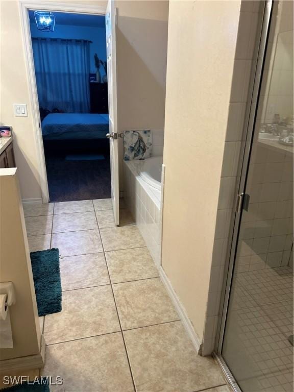 bathroom featuring tile patterned flooring, plus walk in shower, and vanity