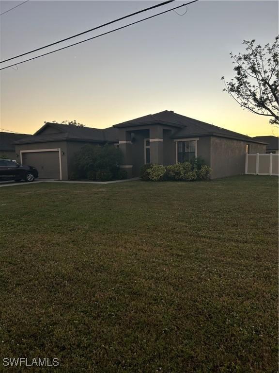 view of front of home with a yard and a garage