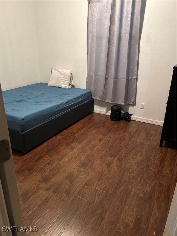 bedroom with dark hardwood / wood-style flooring