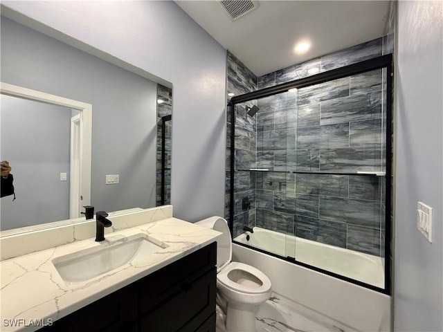 full bathroom featuring enclosed tub / shower combo, vanity, and toilet