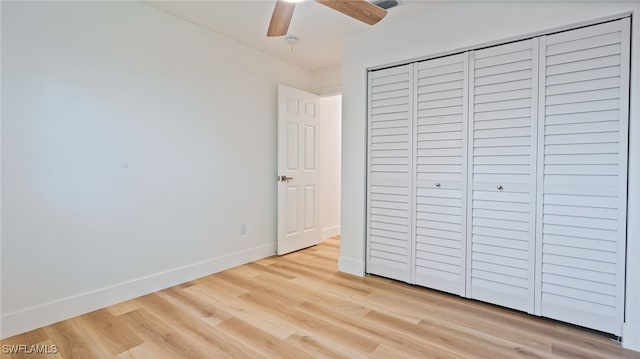 unfurnished bedroom featuring light hardwood / wood-style flooring, a closet, and ceiling fan