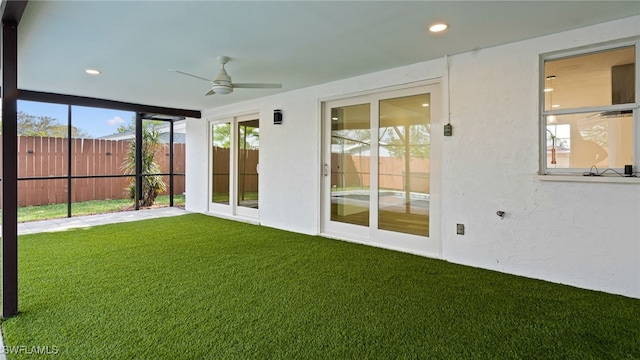 unfurnished sunroom with ceiling fan