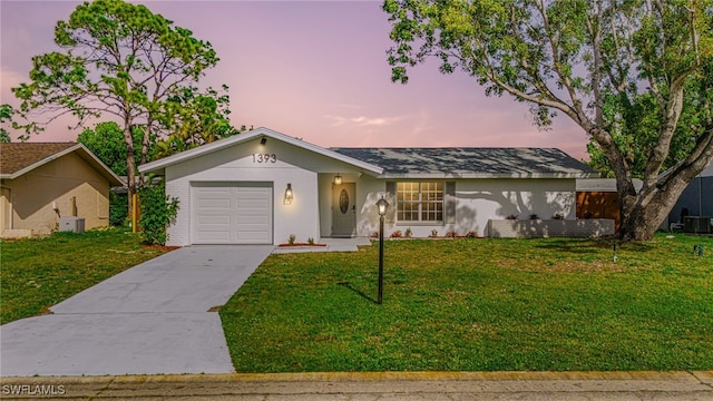 single story home featuring a garage and a lawn