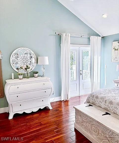 bedroom with vaulted ceiling, access to outside, and dark hardwood / wood-style flooring