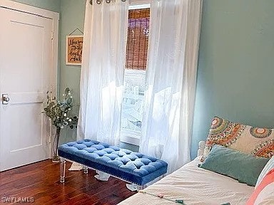 bedroom with dark wood-type flooring