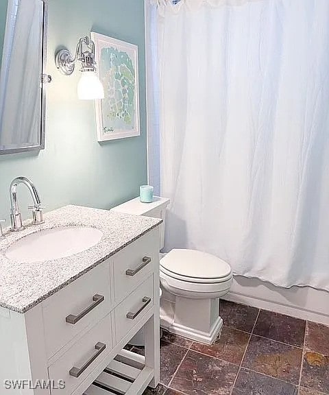 full bathroom featuring shower / bath combination with curtain, vanity, and toilet