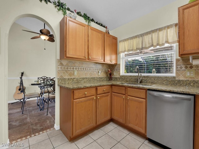 kitchen featuring sink, dishwasher, ceiling fan, light stone countertops, and decorative backsplash