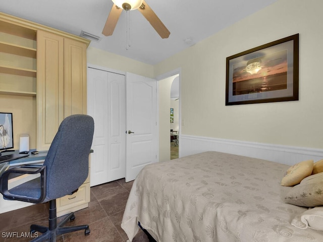 bedroom with dark tile patterned floors, ceiling fan, and a closet