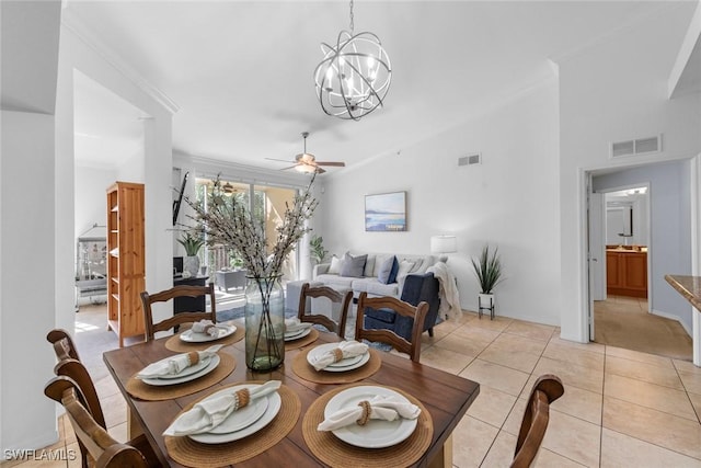 tiled dining space featuring ornamental molding, lofted ceiling, and ceiling fan with notable chandelier