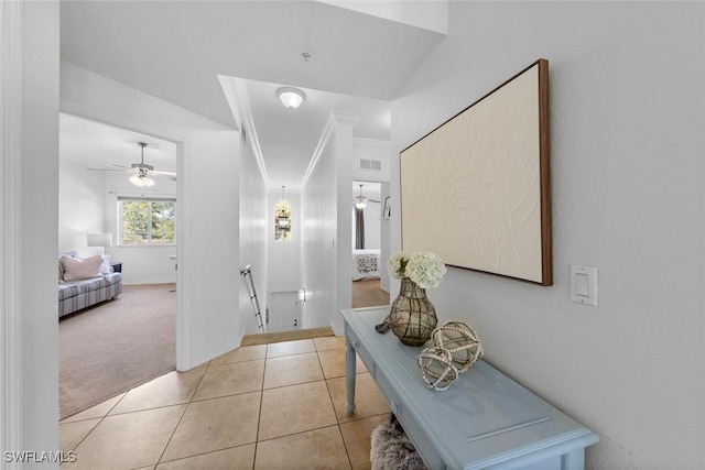 corridor with crown molding and light colored carpet