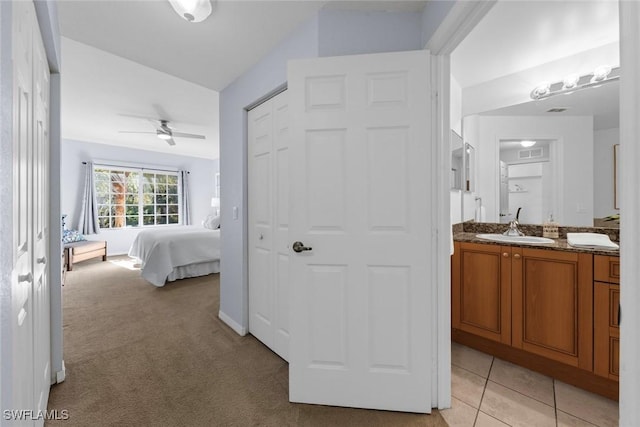 bedroom featuring ceiling fan, sink, and light colored carpet