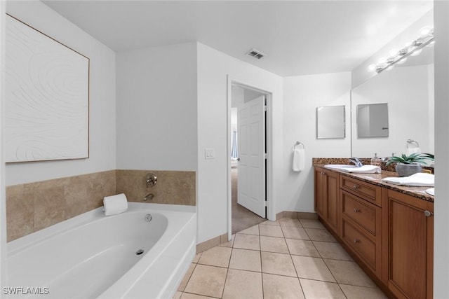 bathroom with tile patterned flooring, vanity, and a bathtub