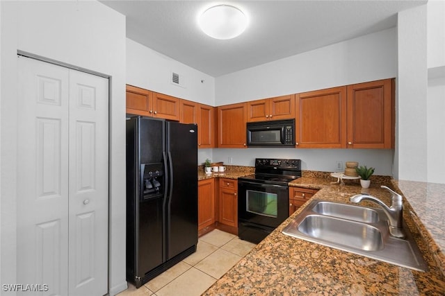 kitchen with sink, light tile patterned floors, and black appliances