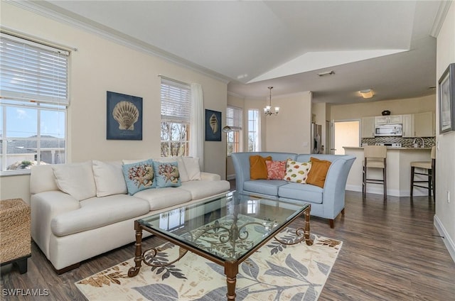 living room with crown molding, vaulted ceiling, a chandelier, and dark hardwood / wood-style flooring