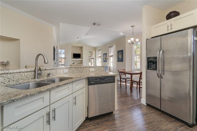 kitchen with appliances with stainless steel finishes, pendant lighting, white cabinetry, sink, and light stone counters