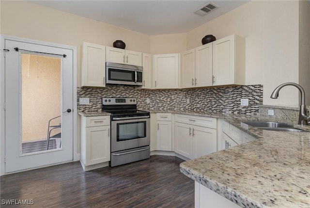 kitchen featuring sink, backsplash, stainless steel appliances, light stone counters, and white cabinets