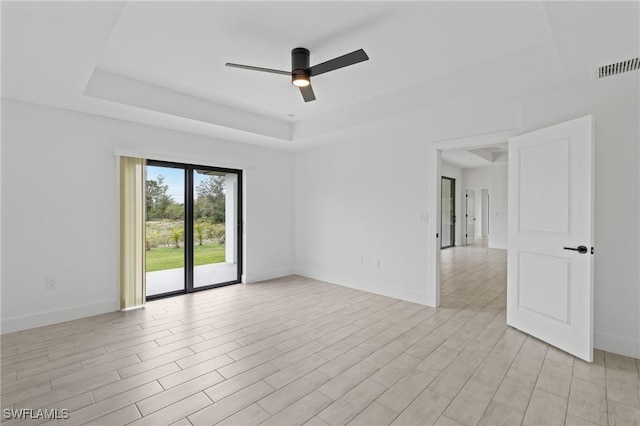 unfurnished room with a raised ceiling and ceiling fan