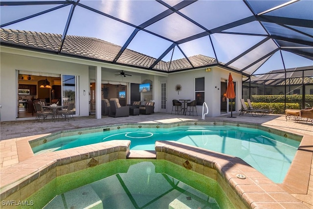 view of pool with a jacuzzi, an outdoor hangout area, ceiling fan, glass enclosure, and a patio area