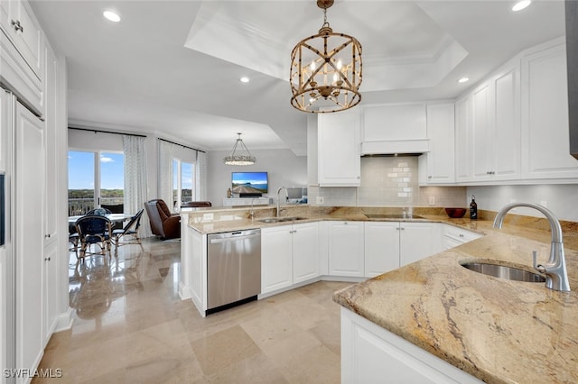 kitchen with pendant lighting, sink, stainless steel dishwasher, and a raised ceiling