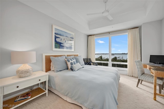 bedroom featuring ceiling fan, a raised ceiling, and light colored carpet