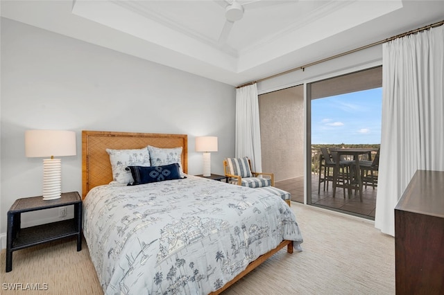 bedroom featuring a tray ceiling, access to outside, and ceiling fan