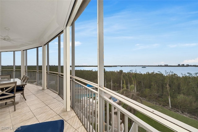 sunroom featuring ceiling fan and a water view