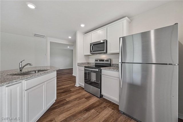 kitchen with light stone counters, sink, white cabinets, and appliances with stainless steel finishes