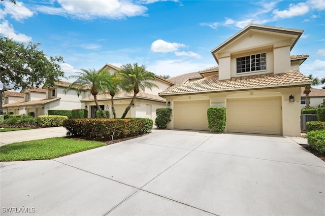 mediterranean / spanish house with a garage and central AC