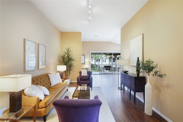 living room featuring dark wood-type flooring, lofted ceiling, and rail lighting