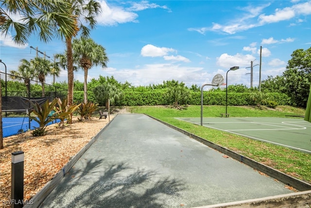 view of sport court featuring a lawn