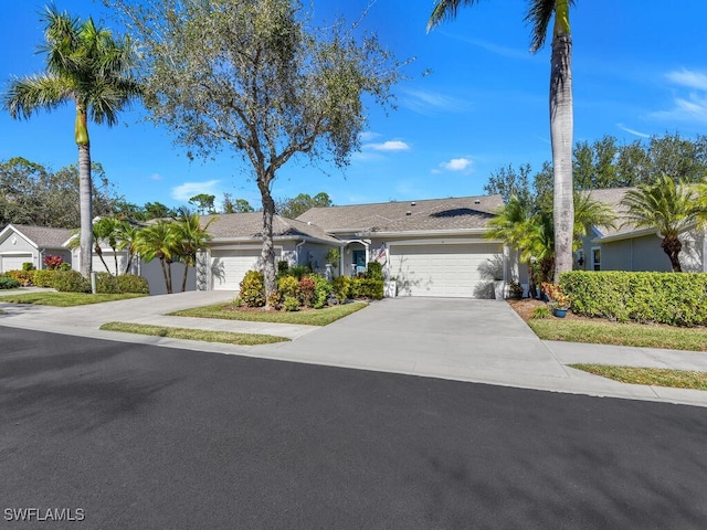 ranch-style house with driveway, an attached garage, and stucco siding