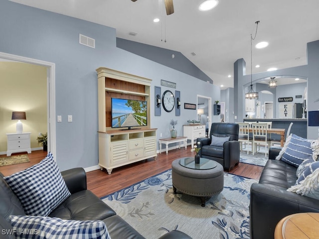 living area with ceiling fan, visible vents, vaulted ceiling, and wood finished floors