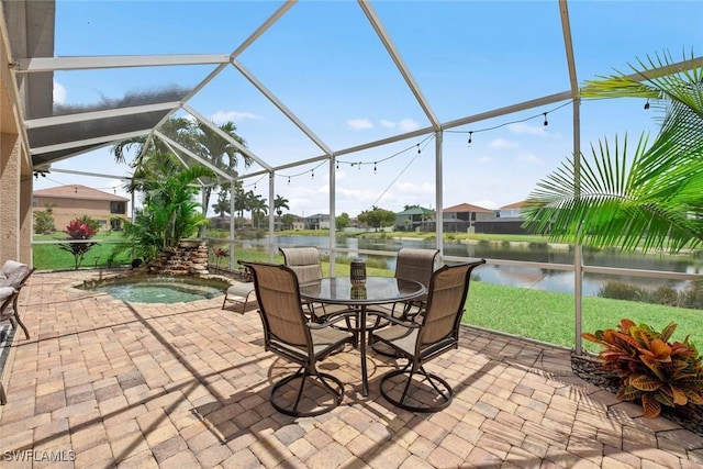 view of patio / terrace featuring a hot tub, glass enclosure, and a water view