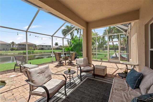 view of patio featuring a lanai and a water view