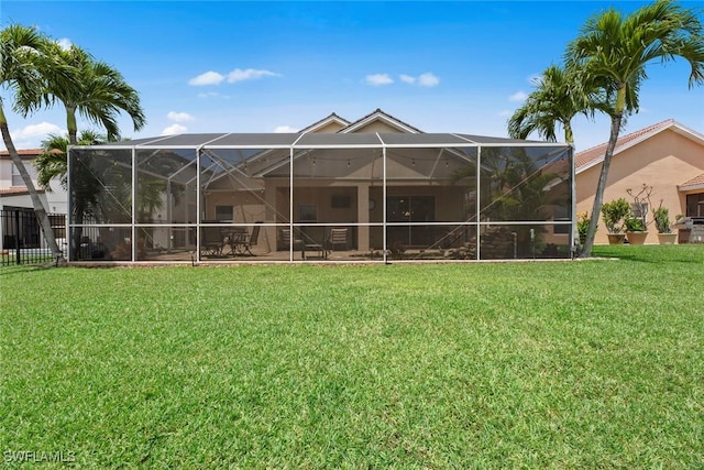 rear view of property with a lanai and a lawn