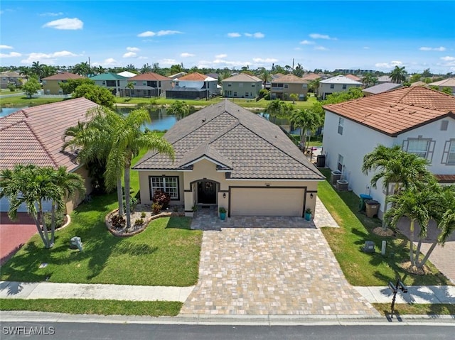 view of front of property featuring a garage, a water view, and a front yard