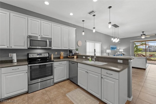 kitchen featuring white cabinetry, appliances with stainless steel finishes, kitchen peninsula, and sink