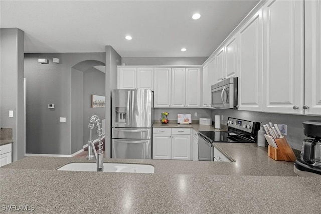 kitchen featuring stainless steel appliances, sink, and white cabinets