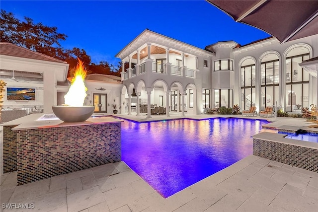 view of swimming pool with a patio and a fire pit