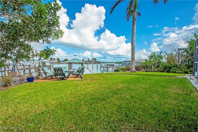 view of yard featuring a water view and a dock