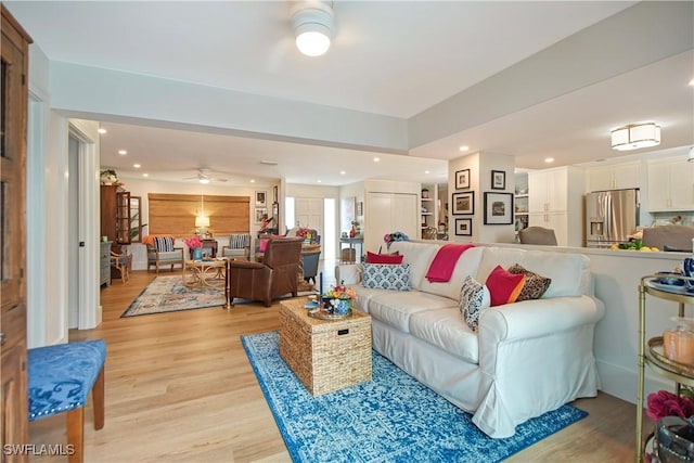 living room with light hardwood / wood-style flooring and ceiling fan