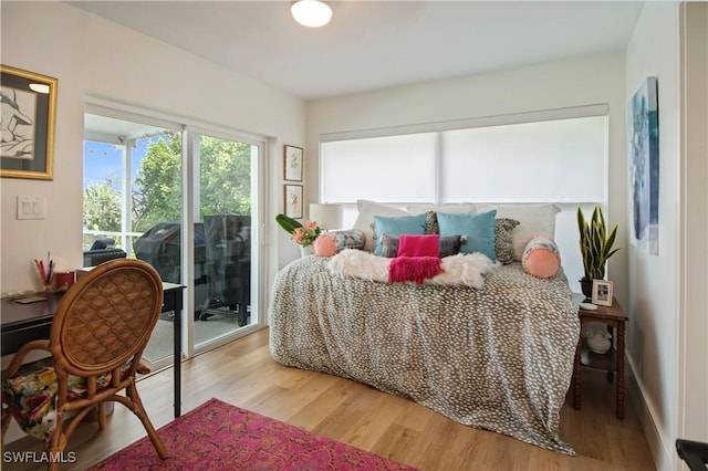 bedroom with access to exterior and wood-type flooring