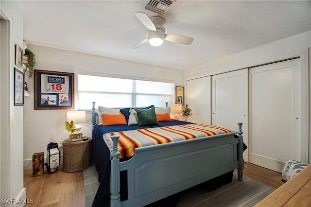 bedroom featuring dark wood-type flooring, ceiling fan, and a closet