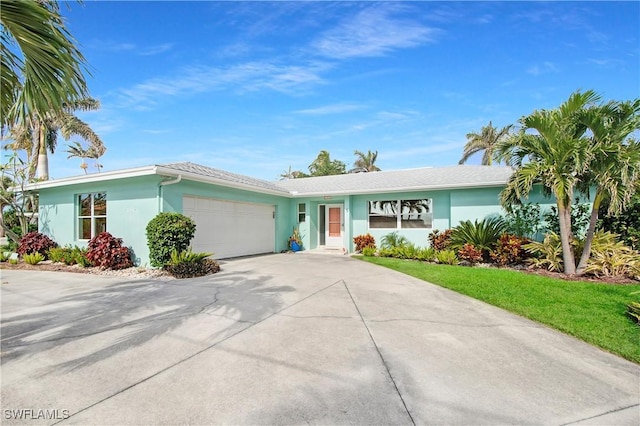 single story home with a garage and a front lawn