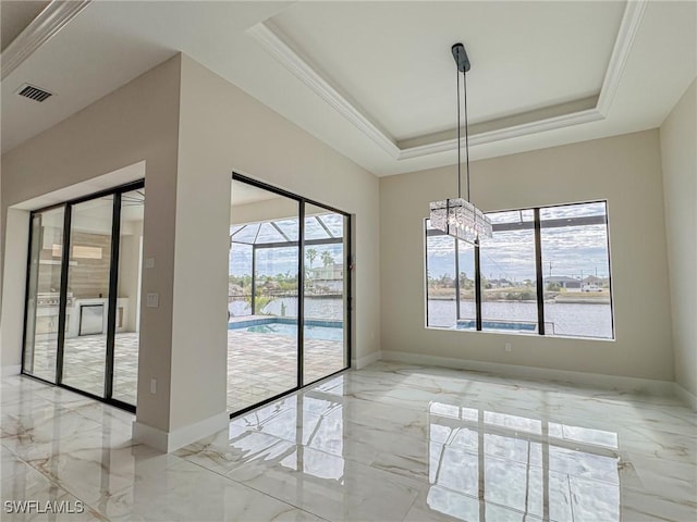 unfurnished dining area with a tray ceiling, ornamental molding, and a water view