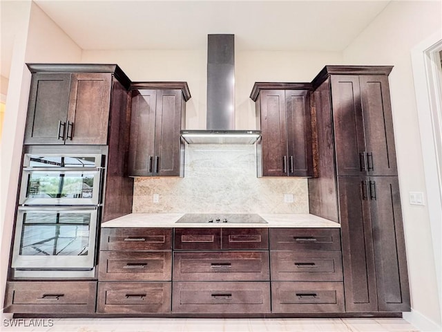 kitchen with wall chimney range hood, double oven, dark brown cabinetry, black electric cooktop, and decorative backsplash