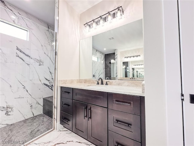 bathroom featuring tiled shower and vanity