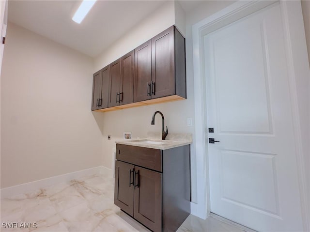 interior space with electric dryer hookup, sink, hookup for a washing machine, and cabinets