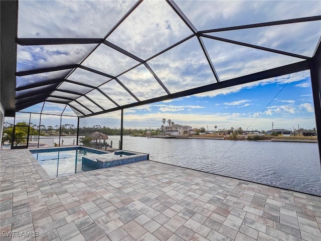 view of pool featuring an in ground hot tub, a water view, a lanai, and a patio area