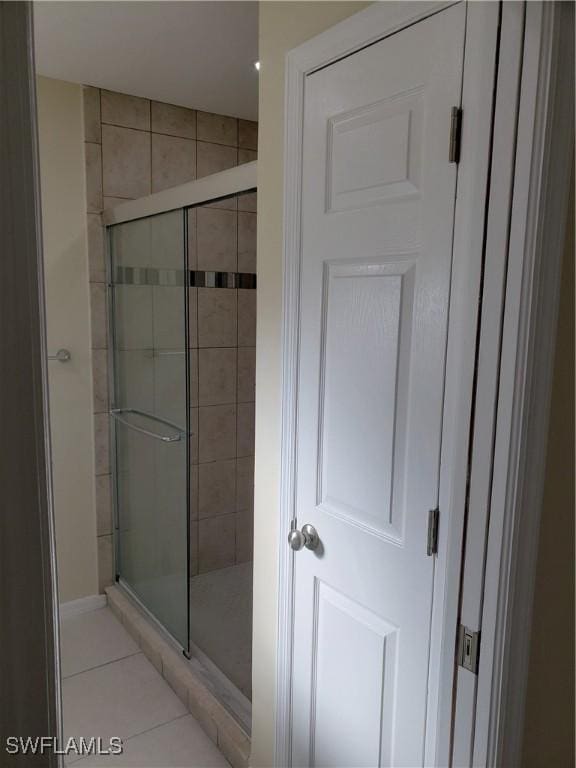 bathroom featuring tile patterned flooring and an enclosed shower